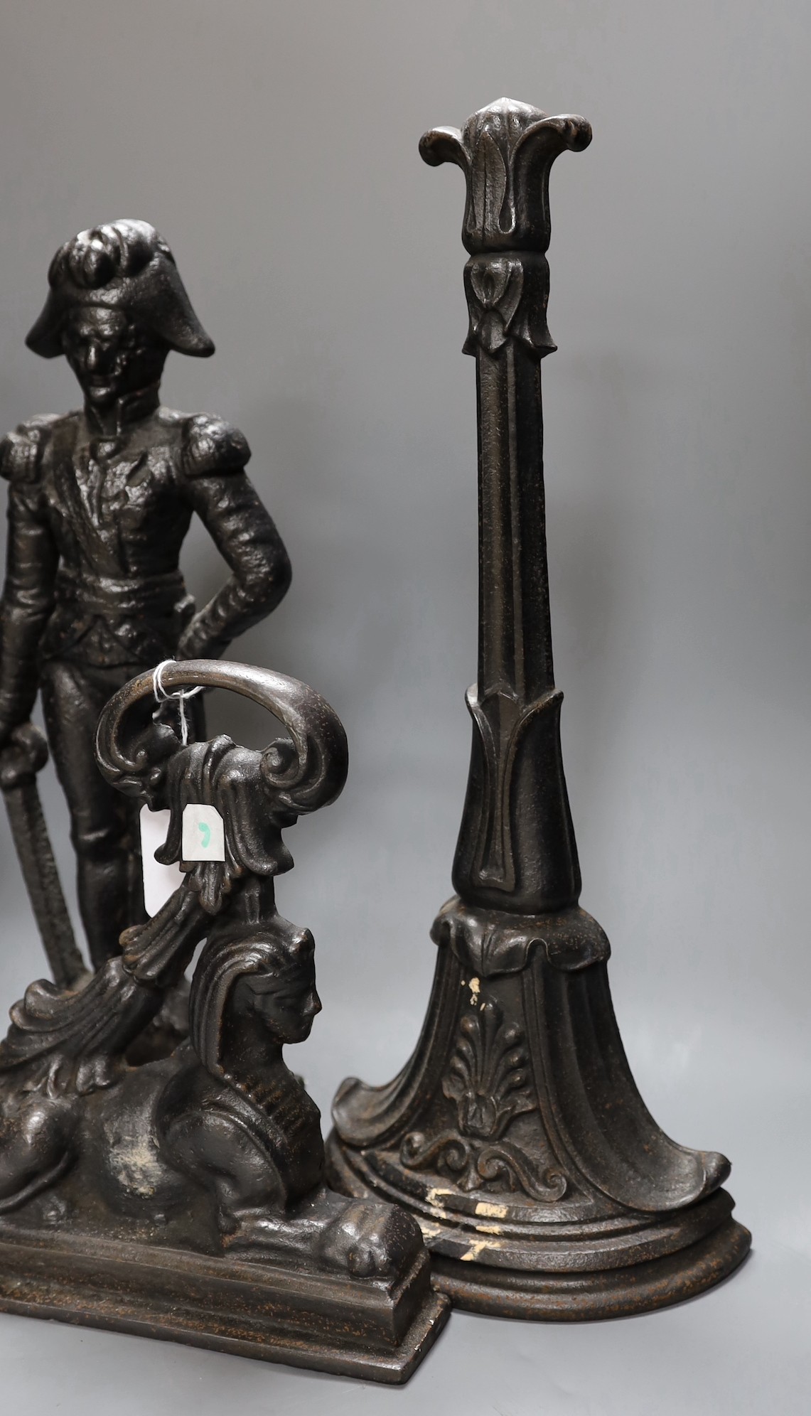 A cherubic cast iron door stop, another of Napoleon, a sphinx and another,(4), Napoleon 40 cms high